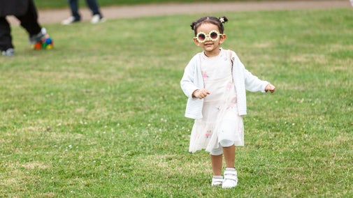 A small child wearing flower shaped sunglasses.